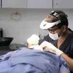Dermatologista realiza um tratamento na pele de uma paciente em uma clínica moderna.