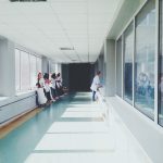 Profissionais de saúde caminham por um corredor de hospital.