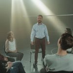 Grupo de pessoas participa de uma conversa de apoio sobre saúde mental em uma sala iluminada